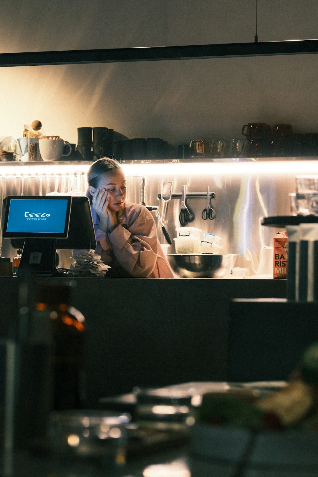 woman-resting-head-on-hand-behind-counter-7j-zobs8ata